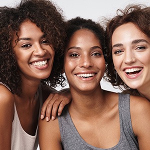 Three women leaning together smiling