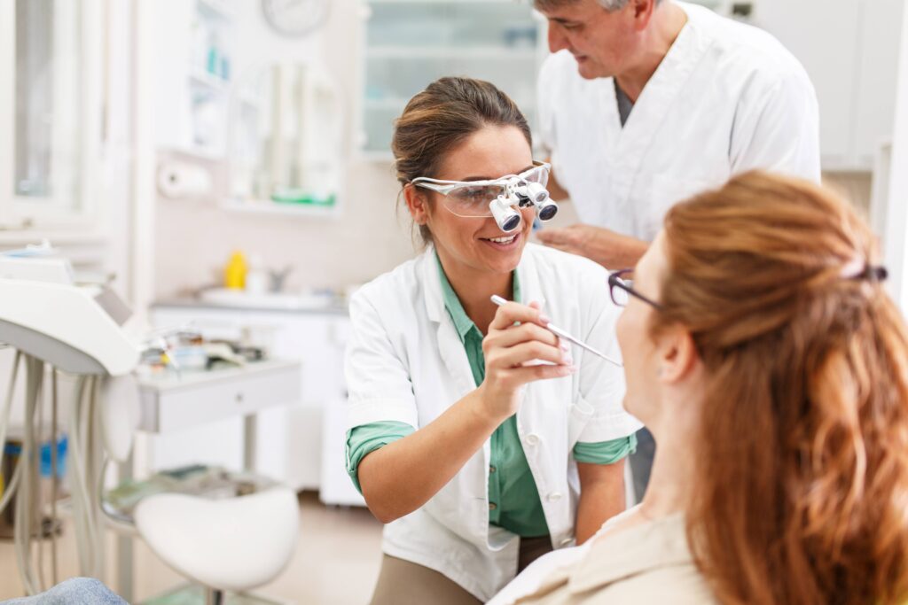 Dentist smiling while talking to patient during exam